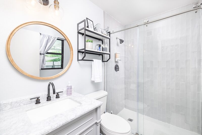 Second bathroom with a glass walk in shower and marble topped vanity