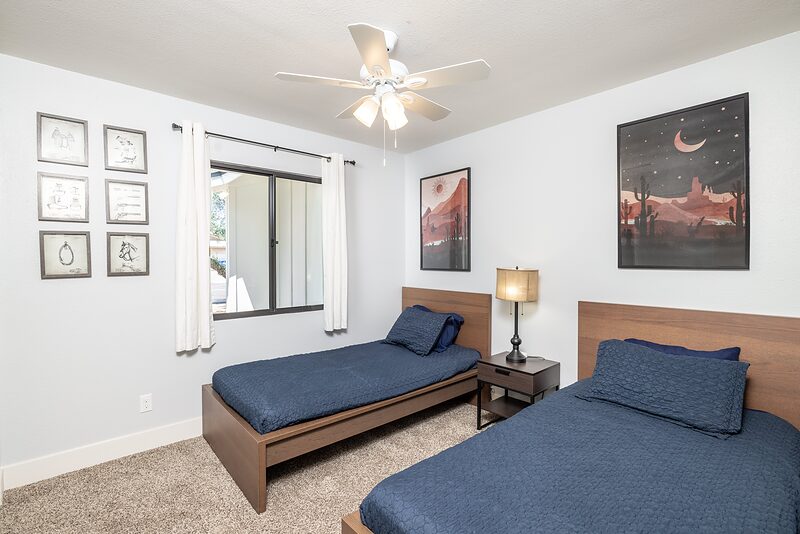 Bedroom with two twin beds and framed desert art on the walls