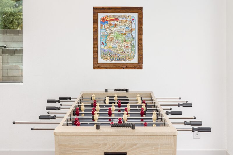 Foosball table below a framed illustrated map of Arizona