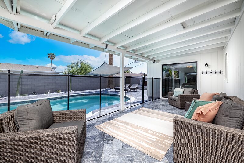 Covered patio with wicker seating looking out over the pool
