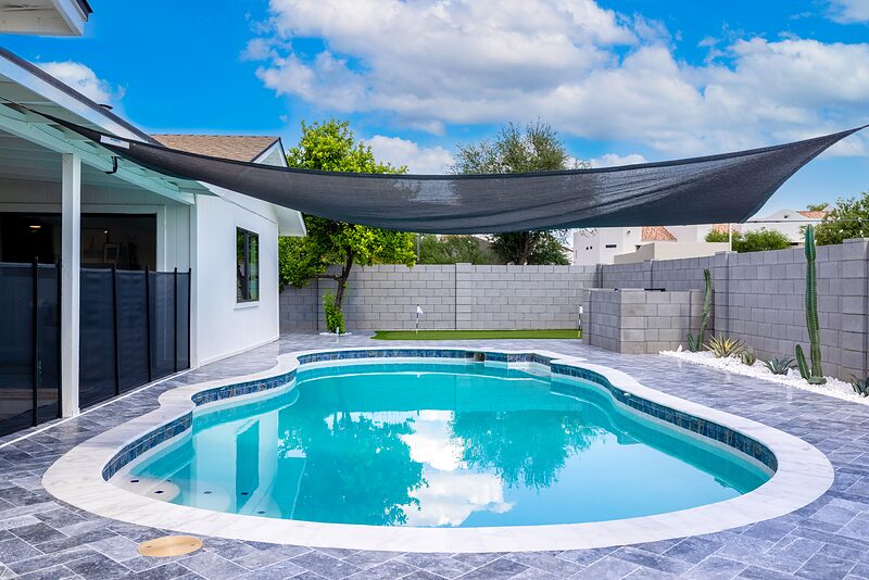 Pool from the patio with a shade sail stretched overhead